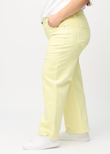 Lysegule loose jeans set fra siden på en plus-size model.