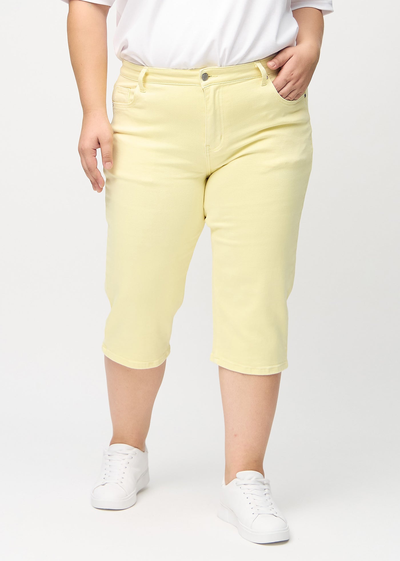 Lysegule regular capris, modelnavn Lemonades, som går lige ned langs benet på en plus-size model, set forfra.