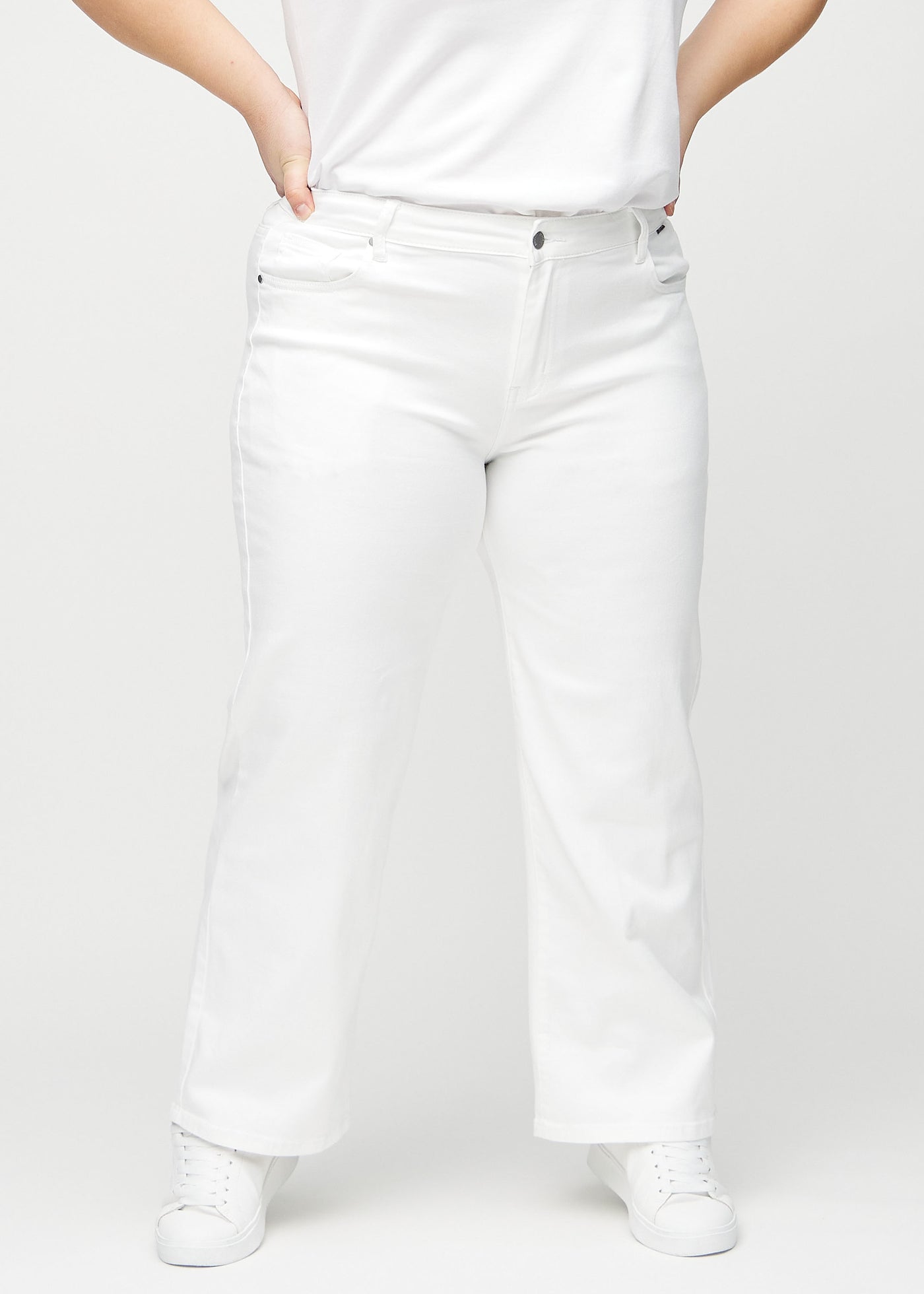 Hvide loose jeans, modelnavn Marguerites, som er løstsiddende med masser af vidde i benene på en plus-size model, set forfra.
