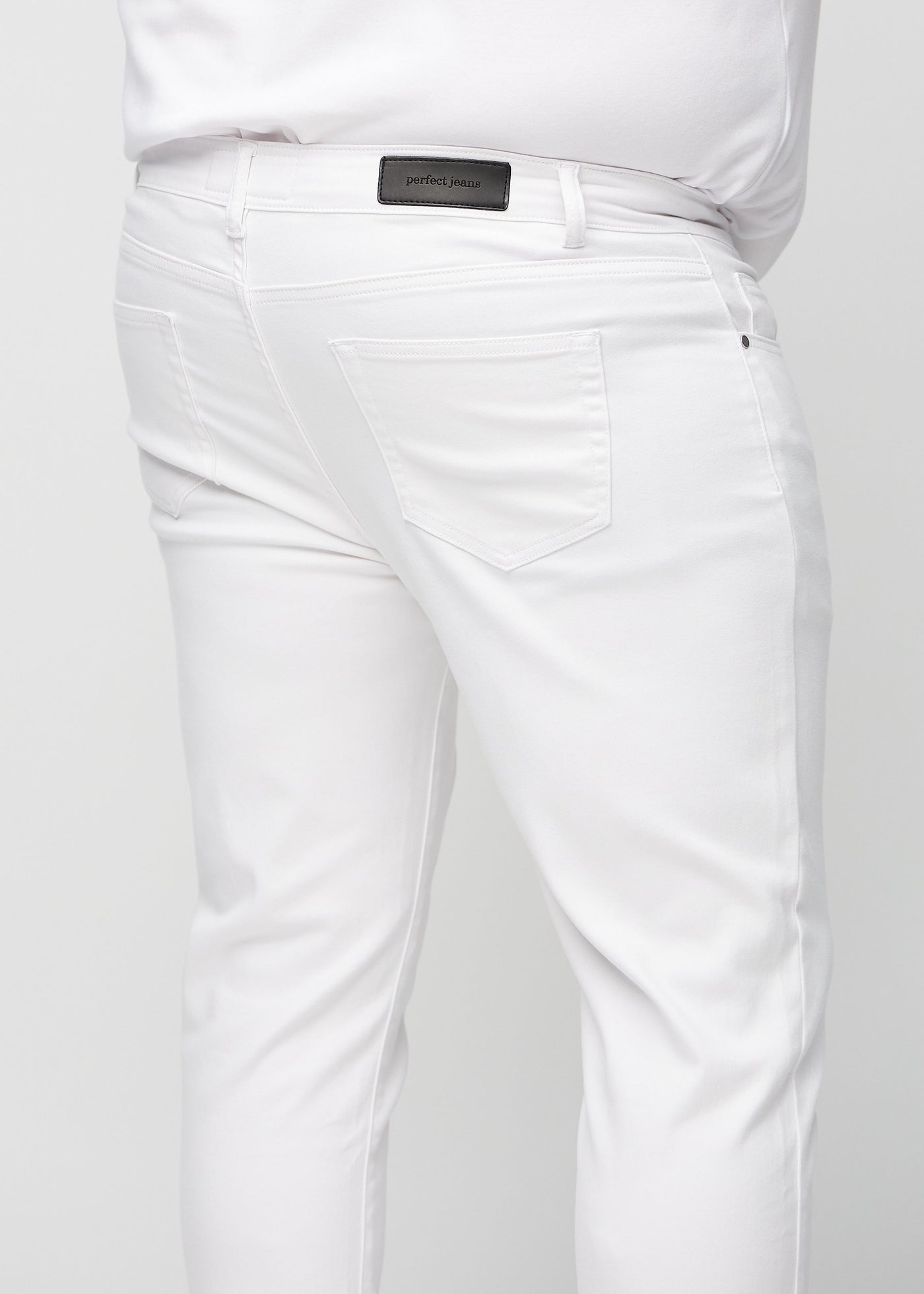 Hvide slim jeans set bagfra tæt på en plus-size model for at vise detaljer.