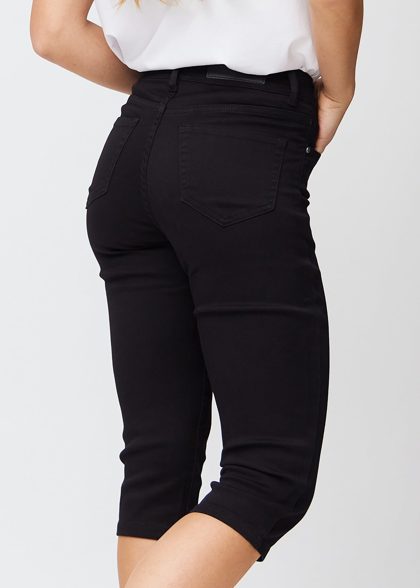 Tæt billede af de sorte slim capris bagfra, så man tydeligt kan se detaljer og lommer.