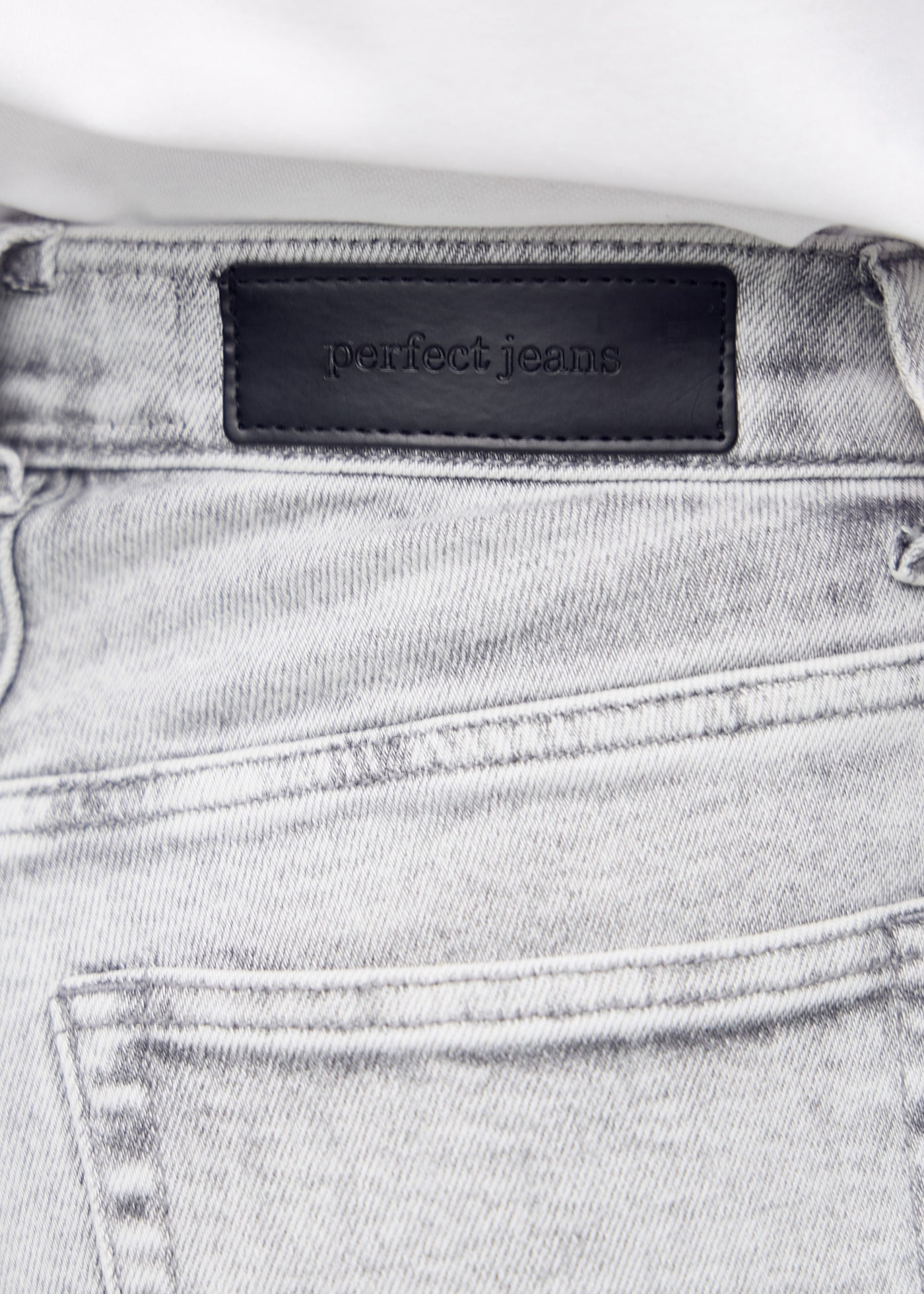 Baglommen på de lysegrå denim slim capris – detaljebillede med fokus på logo og denimtekstur.