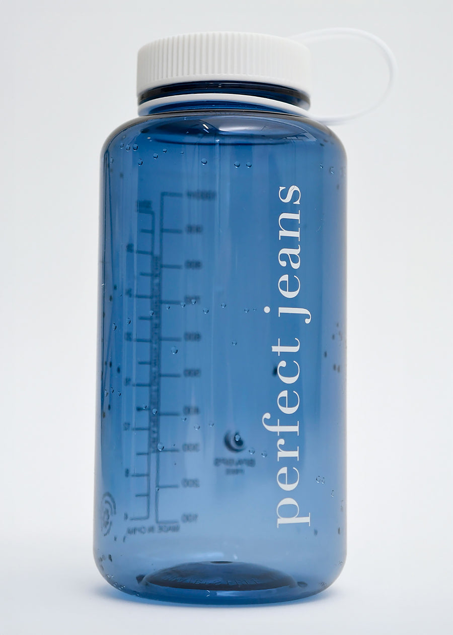 Gennemsigtig vandflaske i mørkeblå plast med hvidt låg og logo.