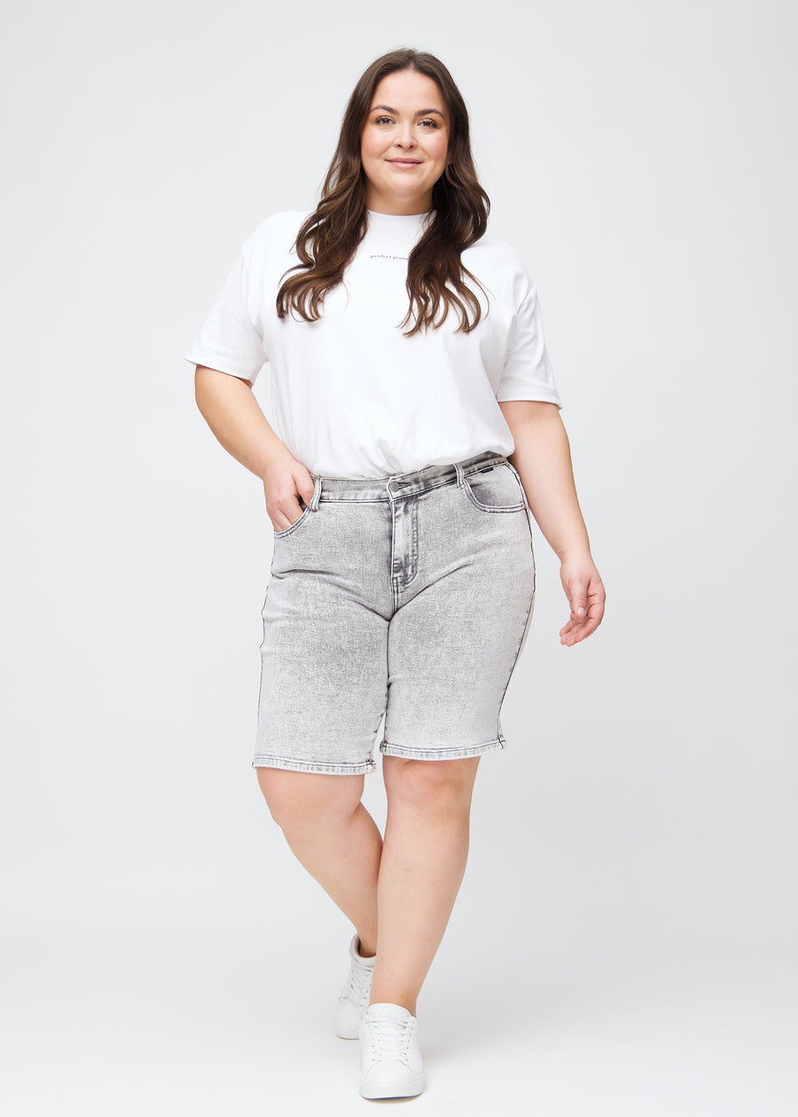 Fuldt billede af en plus-size model i lysegrå denim regular middle shorts.