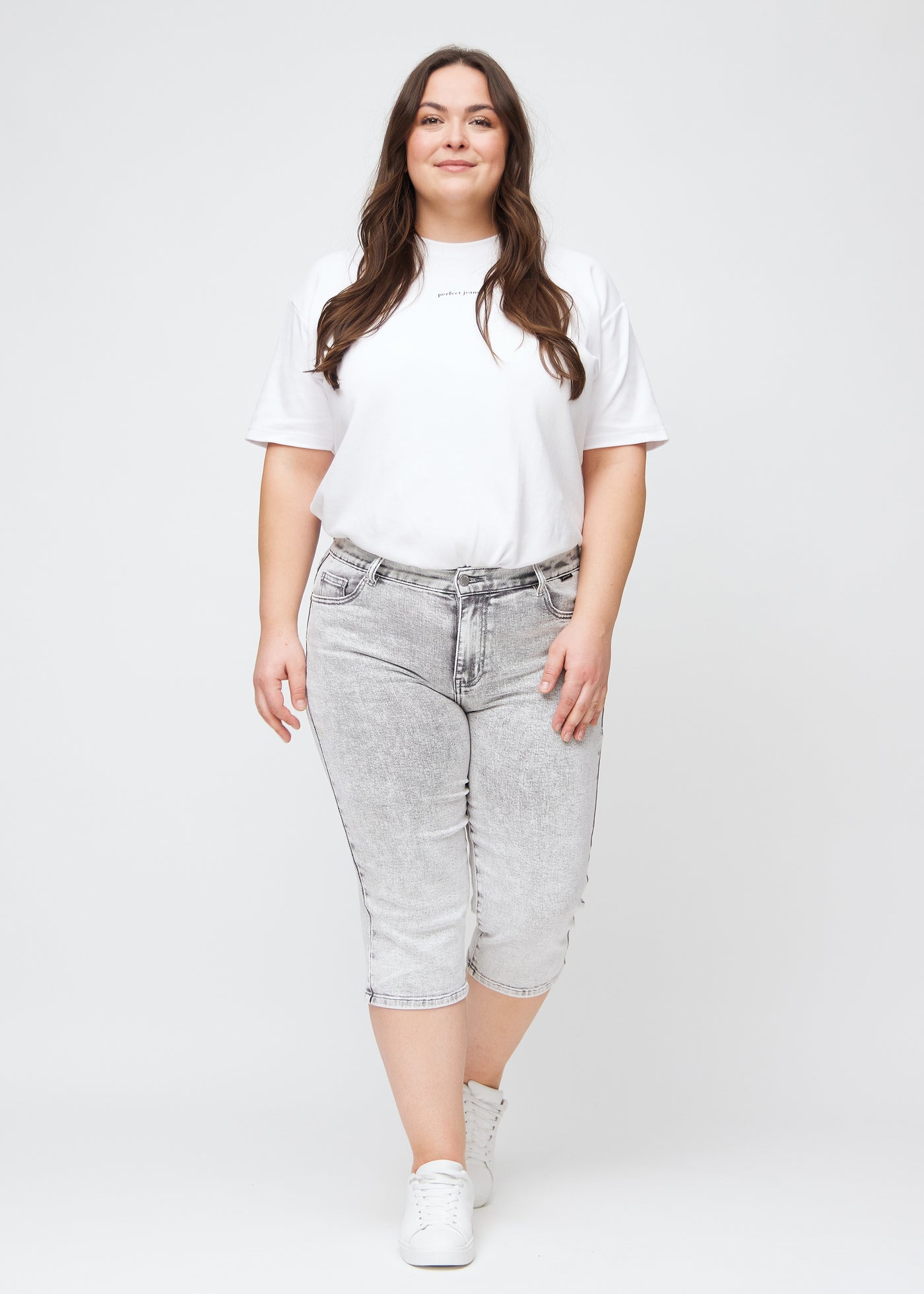 Fuldt billede af en plus-size model i lysegrå denim regular capris.