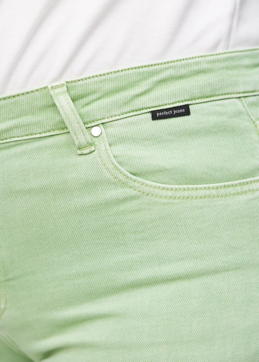 Forlommen på et par lysegrønne loose jeans, hvor man kan se logoet på en plus-size model.