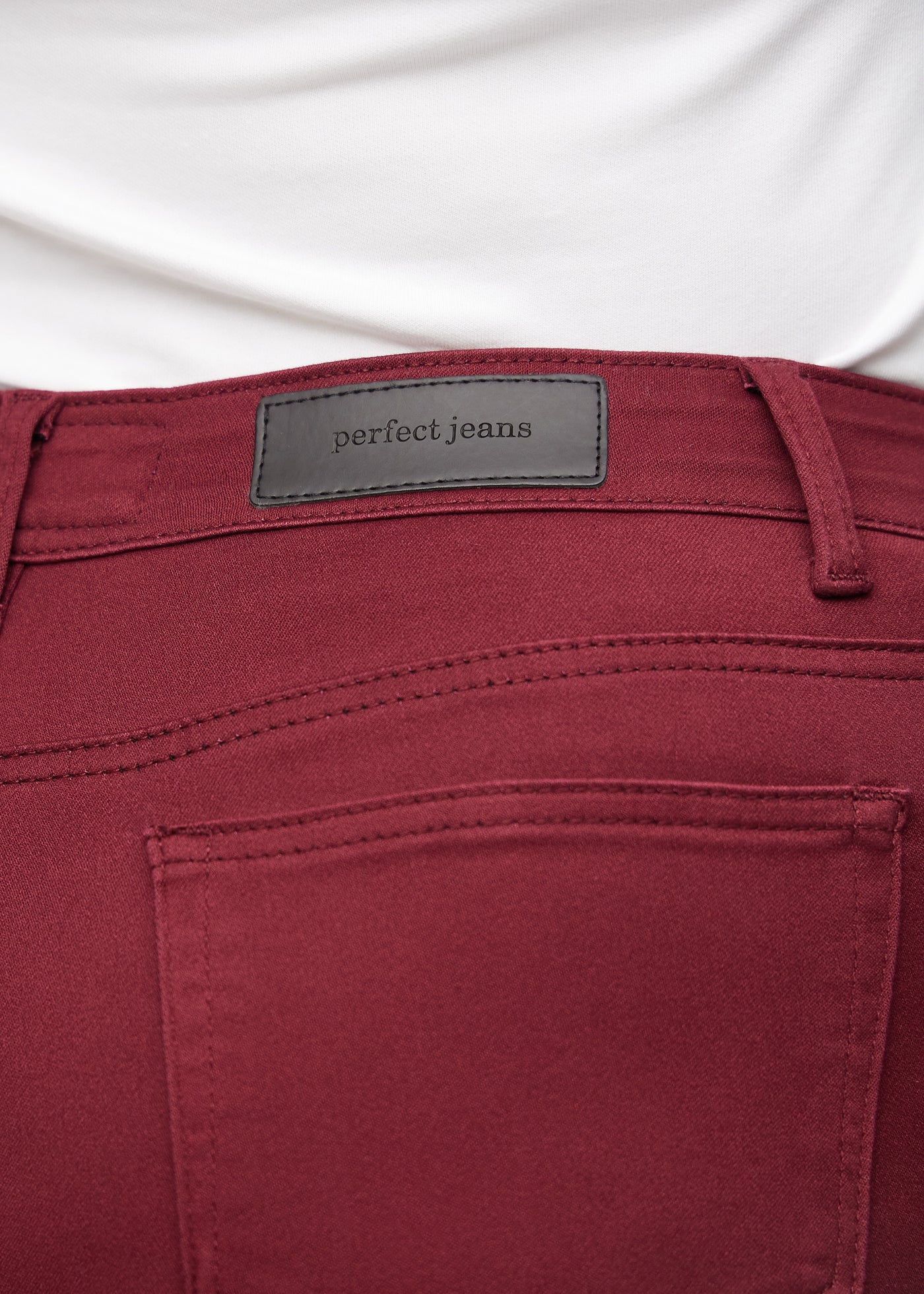 Baglommen på et par mørkerøde regular jeans, hvor man kan se logoet på en plus-size model.