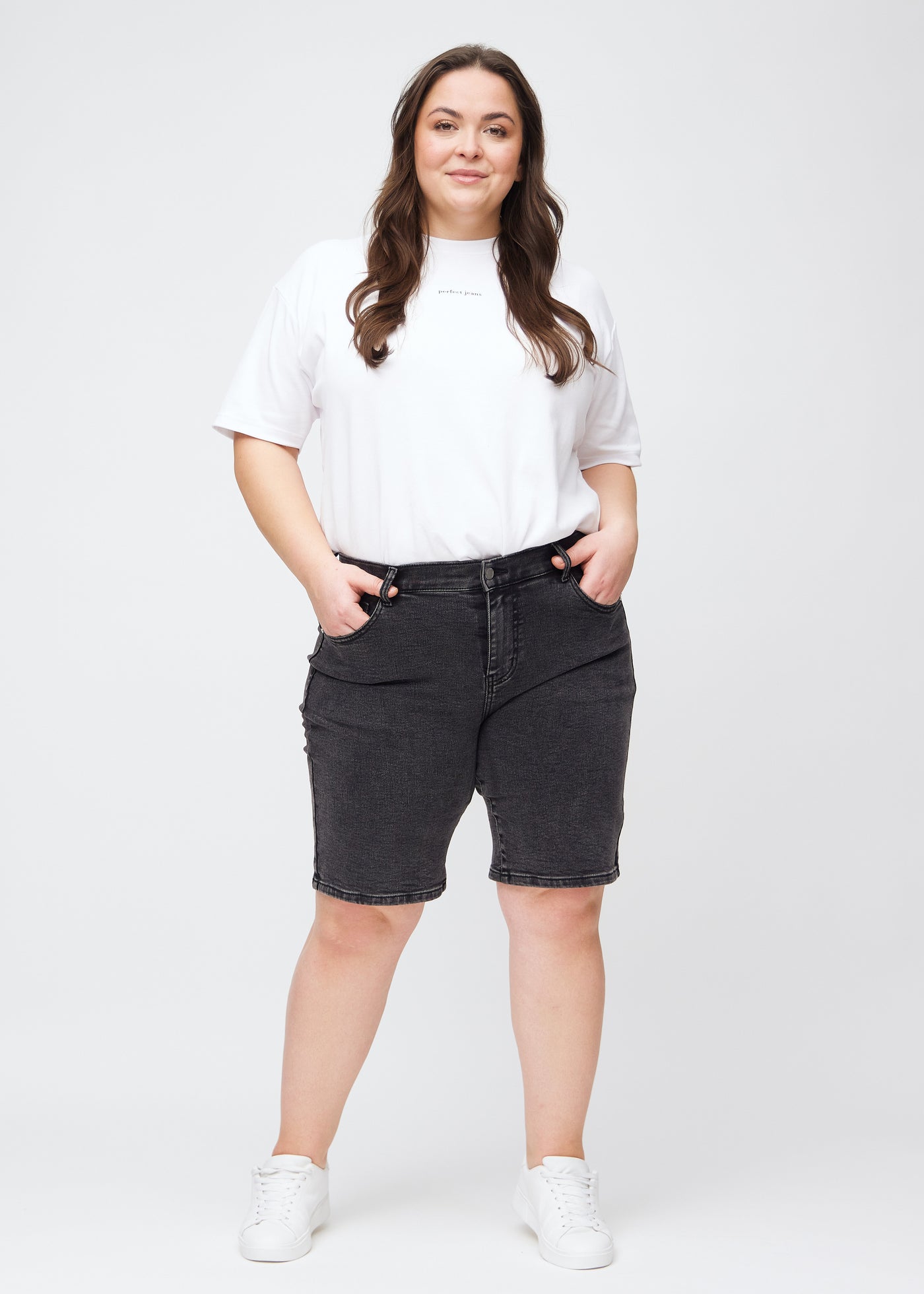 Plus-size model går ind i billedet, strækker i sine shorts, viser dem frem ved at dreje rundt, og forlader derefter billedet.