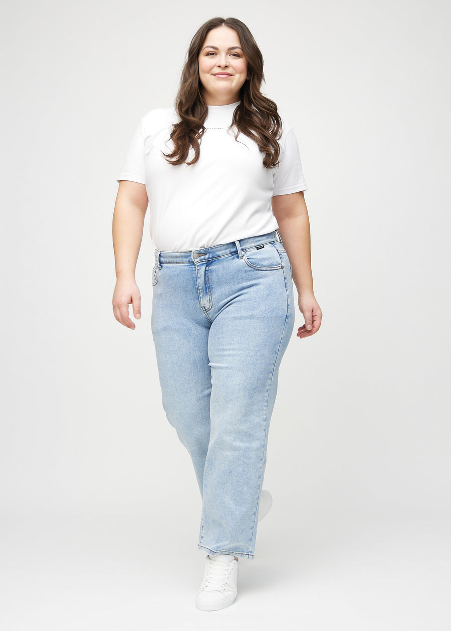 Fuldt billede af en plus-size model i lys denim loose jeans.