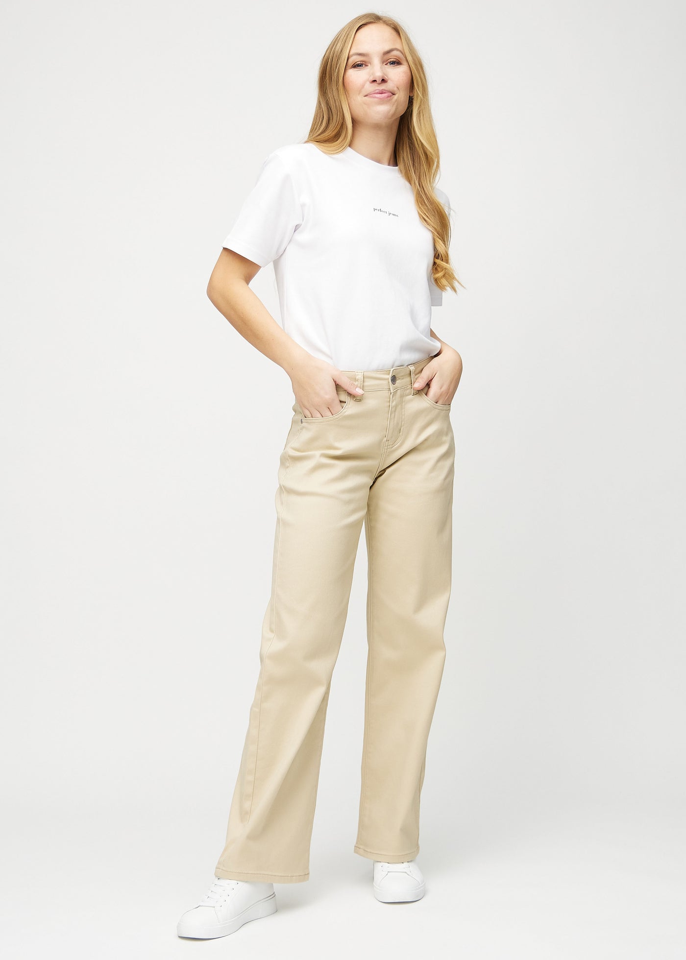 Fuldt billede af model i beige loose jeans.