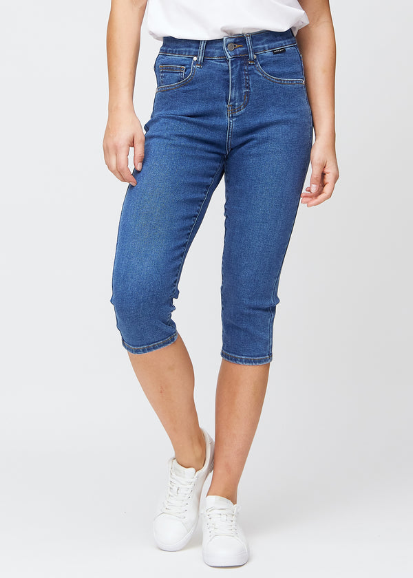 Mørkeblå denim slim capris, farve Oceans, med tætsiddende pasform der former benene og slutter lige under knæet – set forfra.