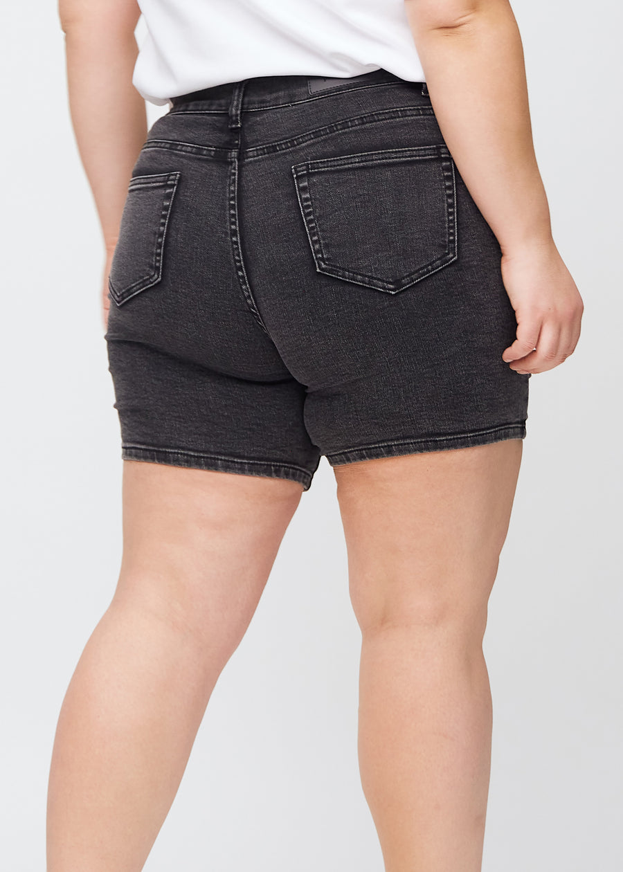 Mørkegrå denim skinny short shorts set bagfra tæt på en plus-size model for at vise detaljer.
