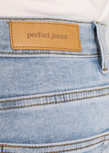 Nærbillede af lyseblå denim med Perfect Jeans læderpatch bagpå i taljen, på en plus-size model.