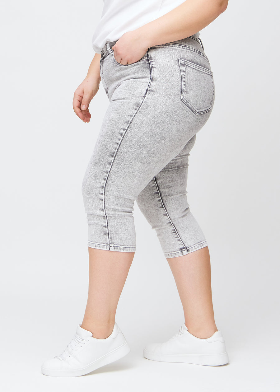 Lysegrå denim skinny capris set fra siden på en plus-size model.