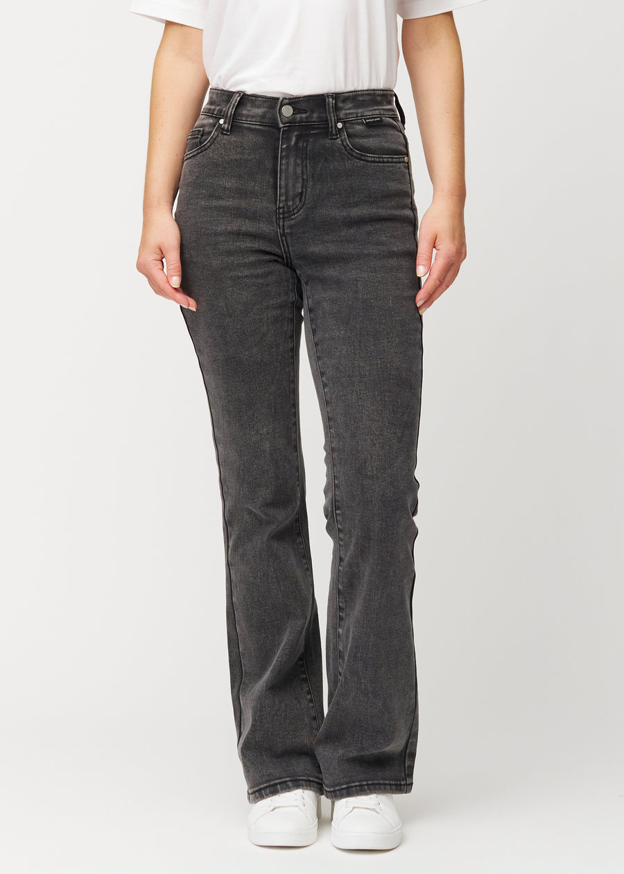 Dunkelgraue Mid-Rise-Bootcut-Jeans in der Farbe Shadows. Vorderansicht an einem Model, an Hüfte und Oberschenkeln anliegend mit leicht ausgestelltem Bein.