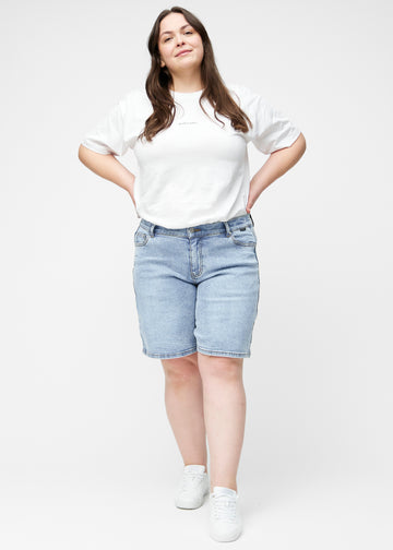 Lockere, hellblaue Denim-Shorts in der Farbe Waves von hinten aus der Nähe am Plus-Size-Model gesehen, um Passform und Details zu zeigen.