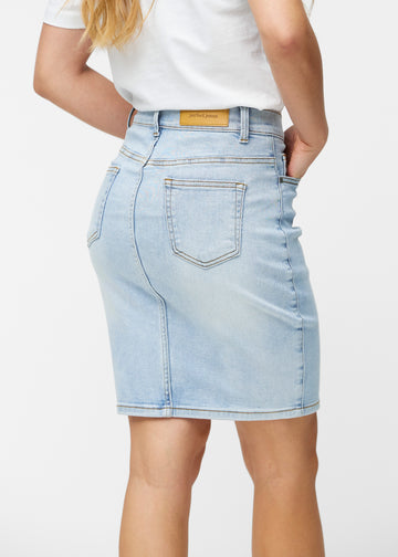 Lyseblå, tætsiddende og knælang denimnederdel set bagfra tæt på for at vise detaljer.