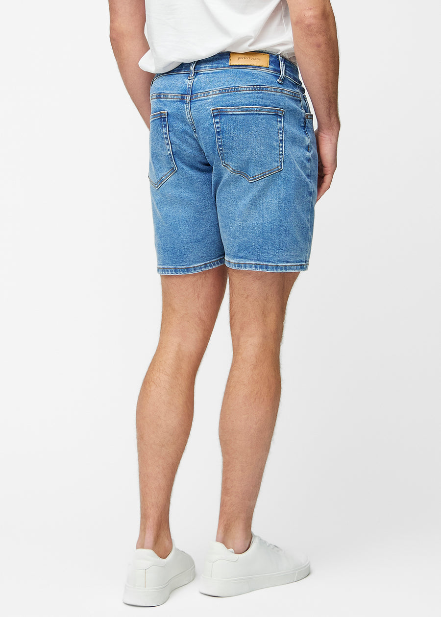 Blaue Denim-Shorts für Herren in der Farbe Rivers von hinten gesehen, sodass die Länge bis knapp über das Knie und die Passform sichtbar sind.