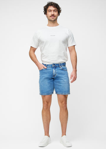 Ganzkörperbild eines Modells in blauen Denim-Shorts für Herren in der Farbe Rivers mit Regular-Passform.
