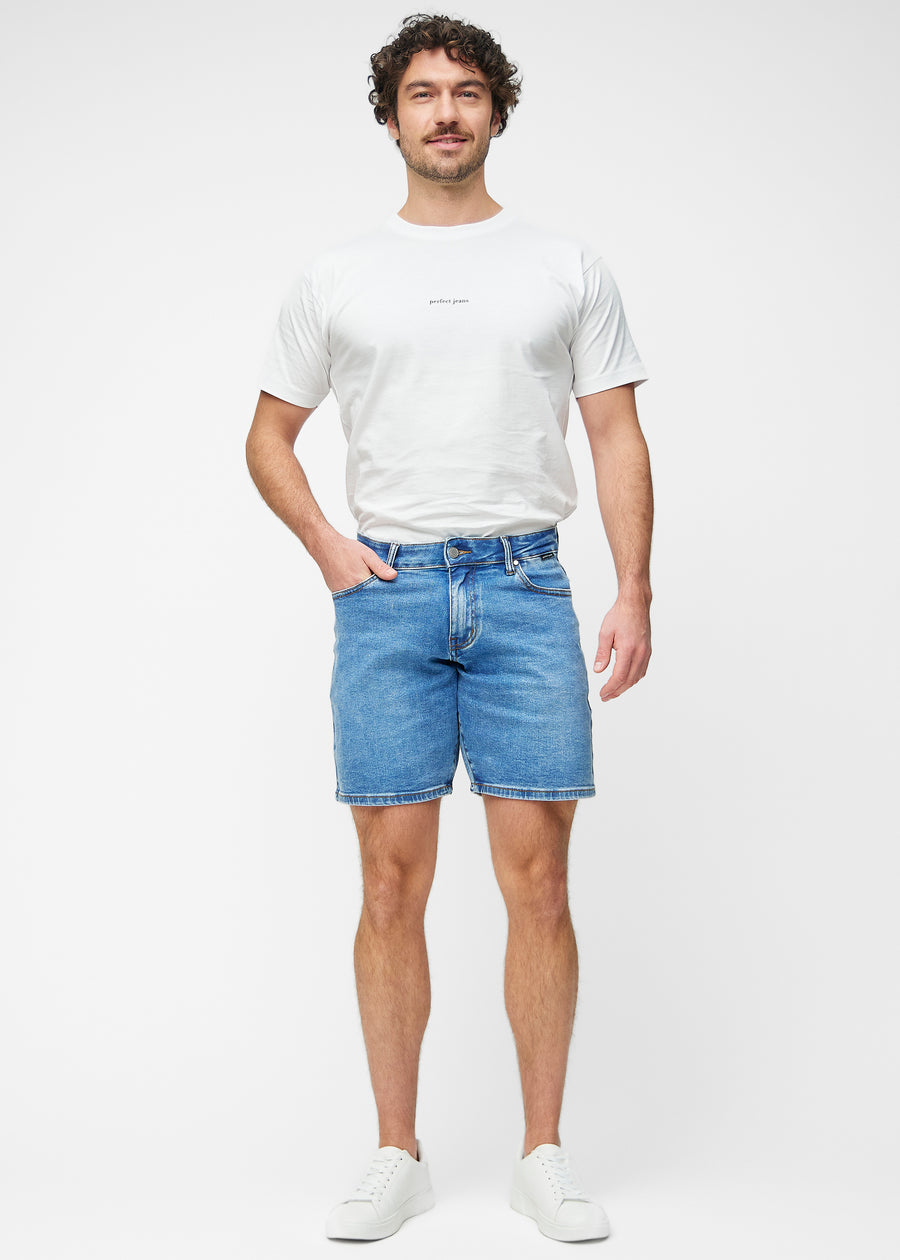 Ganzkörperbild eines Modells in blauen Denim-Shorts für Herren in der Farbe Rivers mit Regular-Passform.