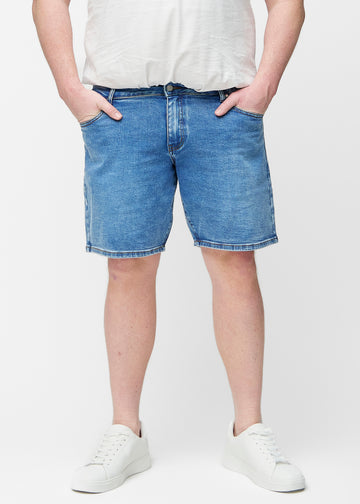 Blaue Denim-Shorts für Herren in der Farbe Rivers mit Regular-Passform von vorne am Plus-Size-Modell gesehen, die natürlich an der Hüfte sitzen und Luft um die Oberschenkel lassen.