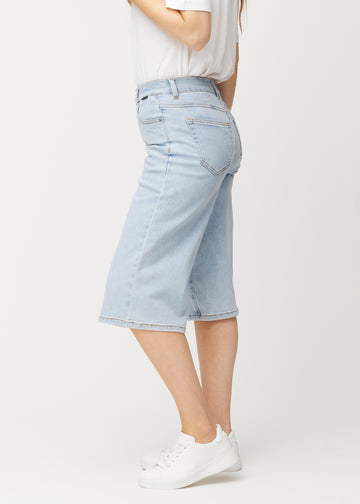 Lockere, hellblaue Waves Denim-Capris von der Seite an einem Model gesehen, mit sichtbarem weitem Schnitt und einer Länge bis knapp unter das Knie.