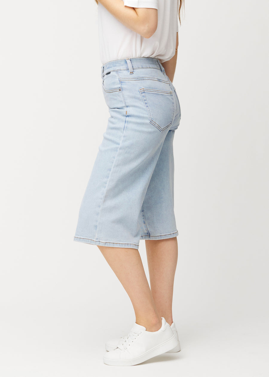 Lockere, hellblaue Waves Denim-Capris von der Seite an einem Model gesehen, mit sichtbarem weitem Schnitt und einer Länge bis knapp unter das Knie.