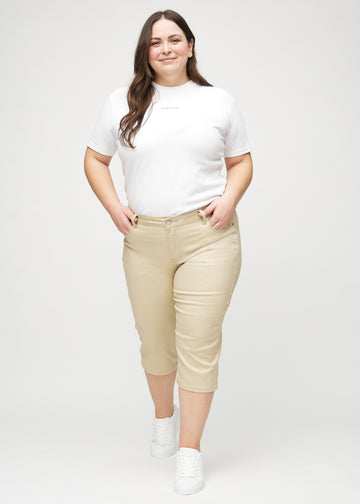Ganzkörperbild eines Plus-Size-Models in beigen regular Capris.