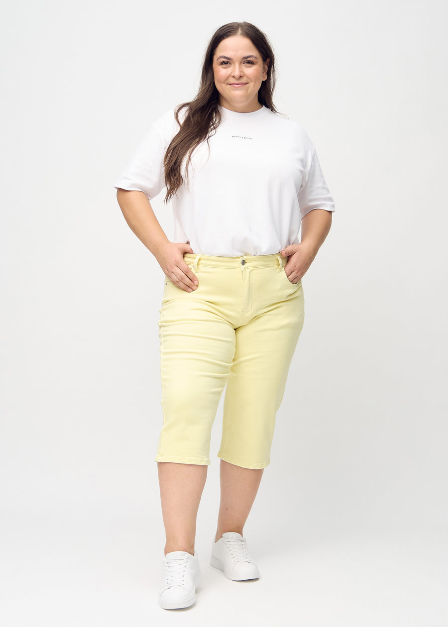 Hellgelbe regular Capris von hinten aus der Nähe an einem Plus-Size-Model gesehen, um Details zu zeigen.