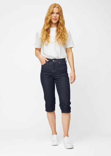 Ganzkörperbild eines Models in tief dunkelblauen Denim-Capris für Damen in der Farbe Midnights mit Regular-Passform.