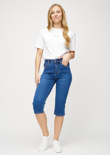 Ganzkörperbild eines Models in dunkelblauen Denim-regular-Capris.