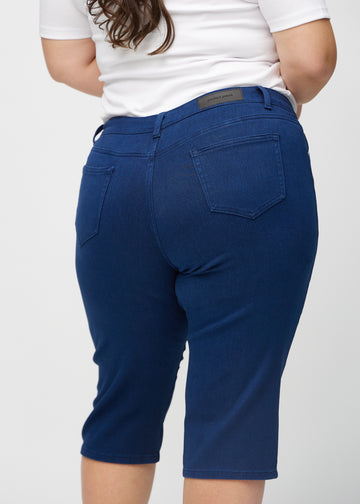 Dunkelblaue regular Capris von hinten aus der Nähe an einem Plus-Size-Model gesehen, um Details zu zeigen.