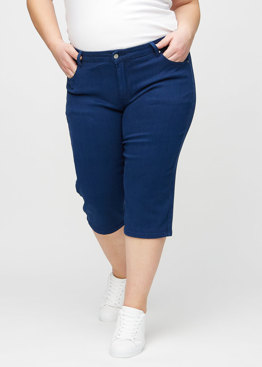 Dunkelblaue regular Capris, Modellname Royals, die eng am Bein anliegen und direkt unter dem Knie enden, an einem Plus-Size-Model von vorne gesehen.