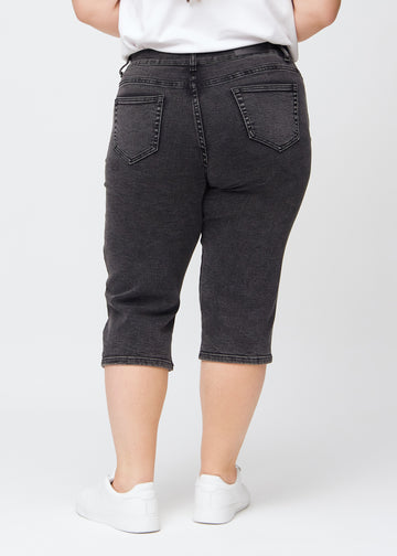 Dunkelgraue Denim-regular-Capris von hinten an einem Plus-Size-Model gesehen, damit man das gesamte Produkt sehen kann.