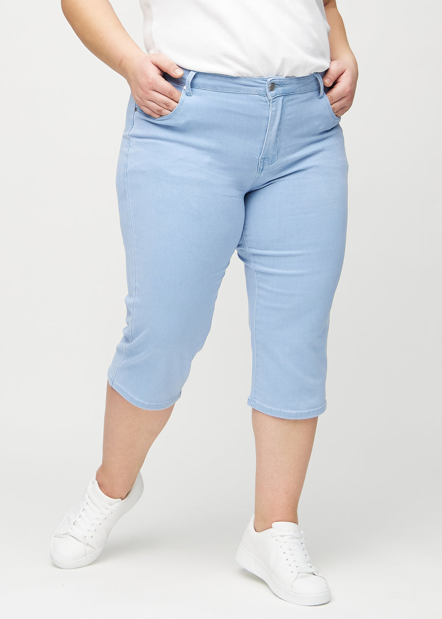 Hellblaue regular Capris, Modellname Skies, die eng am Bein anliegen und knapp unter dem Knie enden, an einem Plus-Size-Model von vorne gesehen.