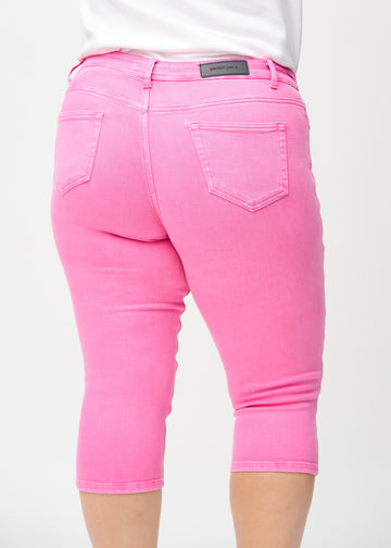 Skinny-Capris für Damen in pastellrosa Jeansstoff, Farbe Flamingos. Nahaufnahme von hinten an einem Plus-Size-Model, zeigt Taschen und Nähte.