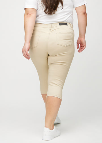 Beige skinny Capris von hinten an einem Plus-Size-Model gesehen, sodass man das ganze Produkt sehen kann.