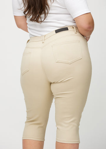 Beige skinny Capris von hinten in Nahaufnahme an einem Plus-Size-Model, um Details zu zeigen.