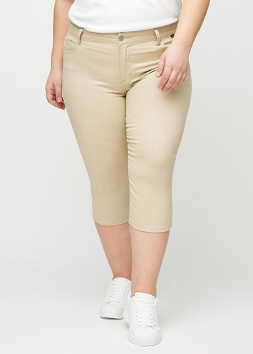 Beige skinny Capris, Modellname Gazelles, die eng am Bein anliegen und bei einem Plus-Size-Model knapp unter dem Knie enden, von vorn gesehen.