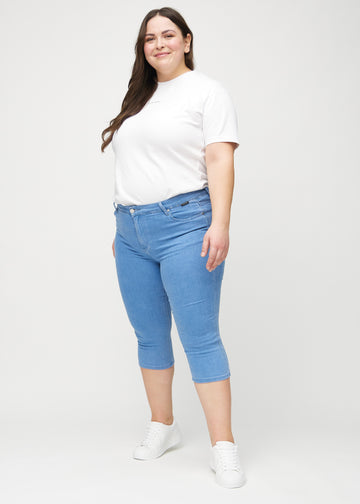 Skinny-Capris für Damen in blauem Jeansstoff, Farbe Geraniums. Ganzkörperansicht eines Plus-Size-Models in den Capris.