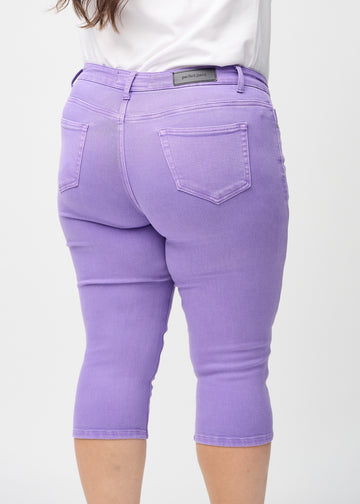 Skinny-Capris für Damen in pastellviolettem Jeansstoff, Farbe Lavenders. Nahaufnahme von hinten an einem Plus-Size-Model, zeigt Taschen und Nähte.