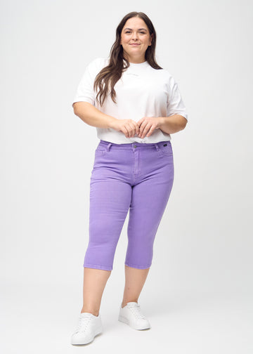 Skinny-Capris für Damen in pastellviolettem Jeansstoff, Farbe Lavenders. Ganzkörperansicht eines Plus-Size-Models in den Capris.