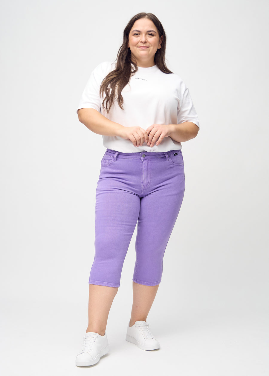 Skinny-Capris für Damen in pastellviolettem Jeansstoff, Farbe Lavenders. Ganzkörperansicht eines Plus-Size-Models in den Capris.