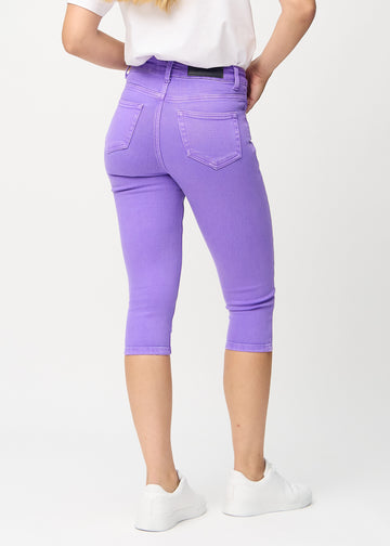Skinny-Capris für Damen in pastellviolettem Jeansstoff, Farbe Lavenders. Rückansicht an einem Model, zeigt die Passform und Gesäßtaschen.