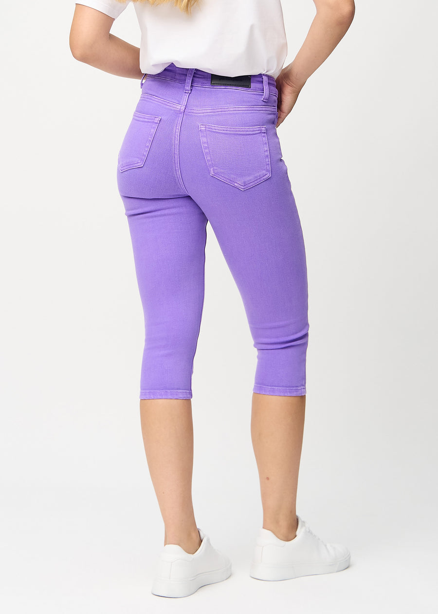 Skinny-Capris für Damen in pastellviolettem Jeansstoff, Farbe Lavenders. Rückansicht an einem Model, zeigt die Passform und Gesäßtaschen.