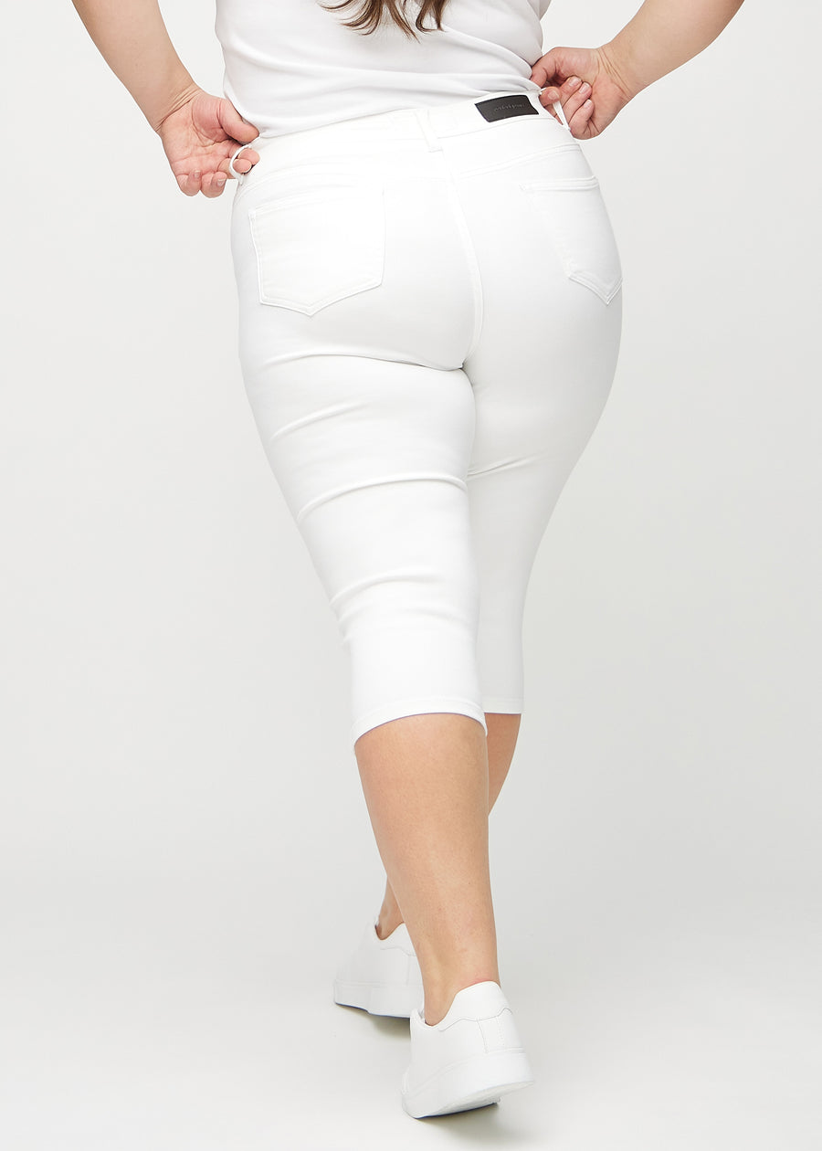 Skinny-Capris für Damen in weißem Jeansstoff, Farbe Marguerites. Rückansicht an einem Plus-Size-Model, zeigt die Passform und Gesäßtaschen.