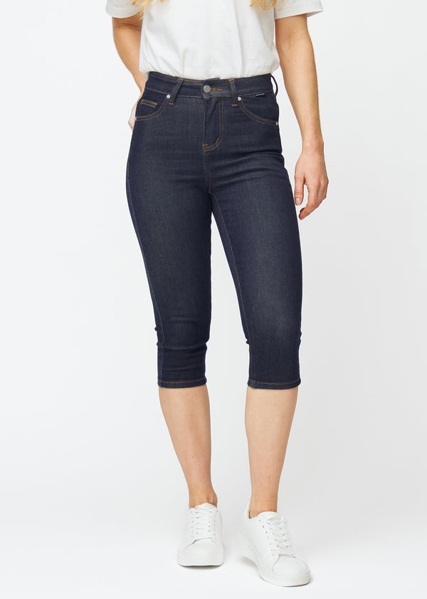 Tief dunkelblaue Denim-Capris für Damen in der Farbe Midnights mit Skinny-Passform, die von der Hüfte bis unter das Knie eng anliegt, von vorne gesehen.