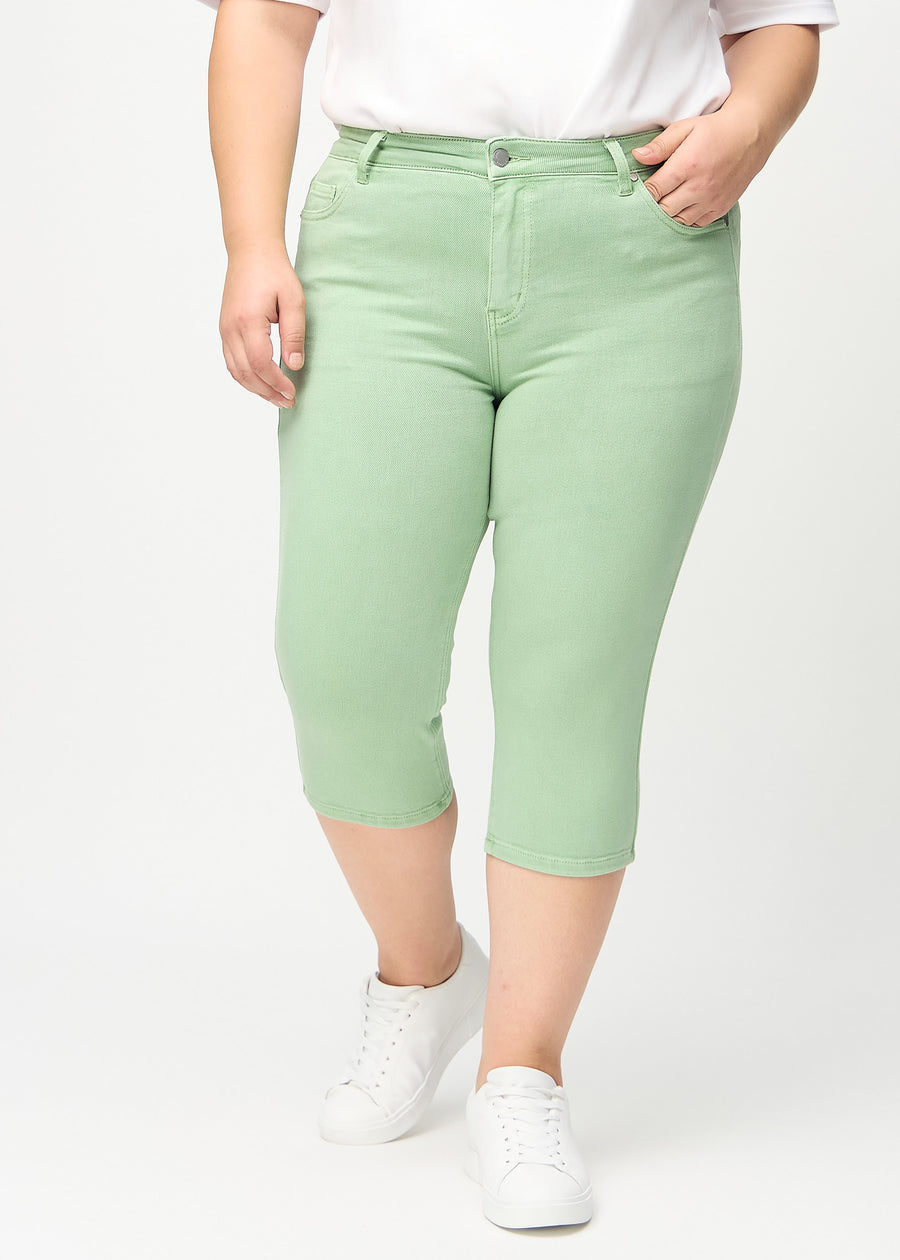Skinny-Capris für Damen in pastellgrünem Jeansstoff, Farbe Mints. Vorderansicht an einem Plus-Size-Model, eng geschnitten bis knapp unter das Knie.
