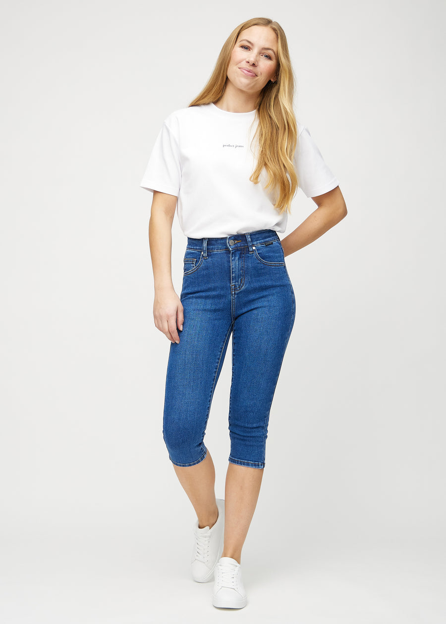 Ganzkörperbild des Models in dunklen Denim-skinny-Capris.