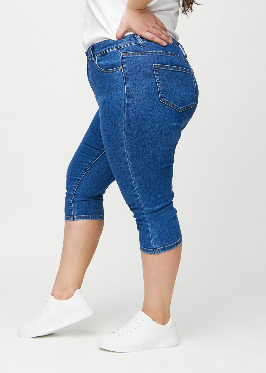 Dunkle Denim-skinny-Capris von der Seite an einem Plus-Size-Model.